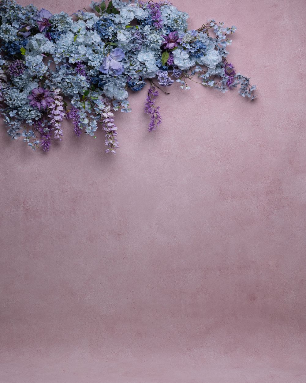Delicate white and purple lilac flowers create a decorative border against a soft pink textured background.