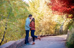 Romantic autumn engagement session with vibrant red and gold foliage.