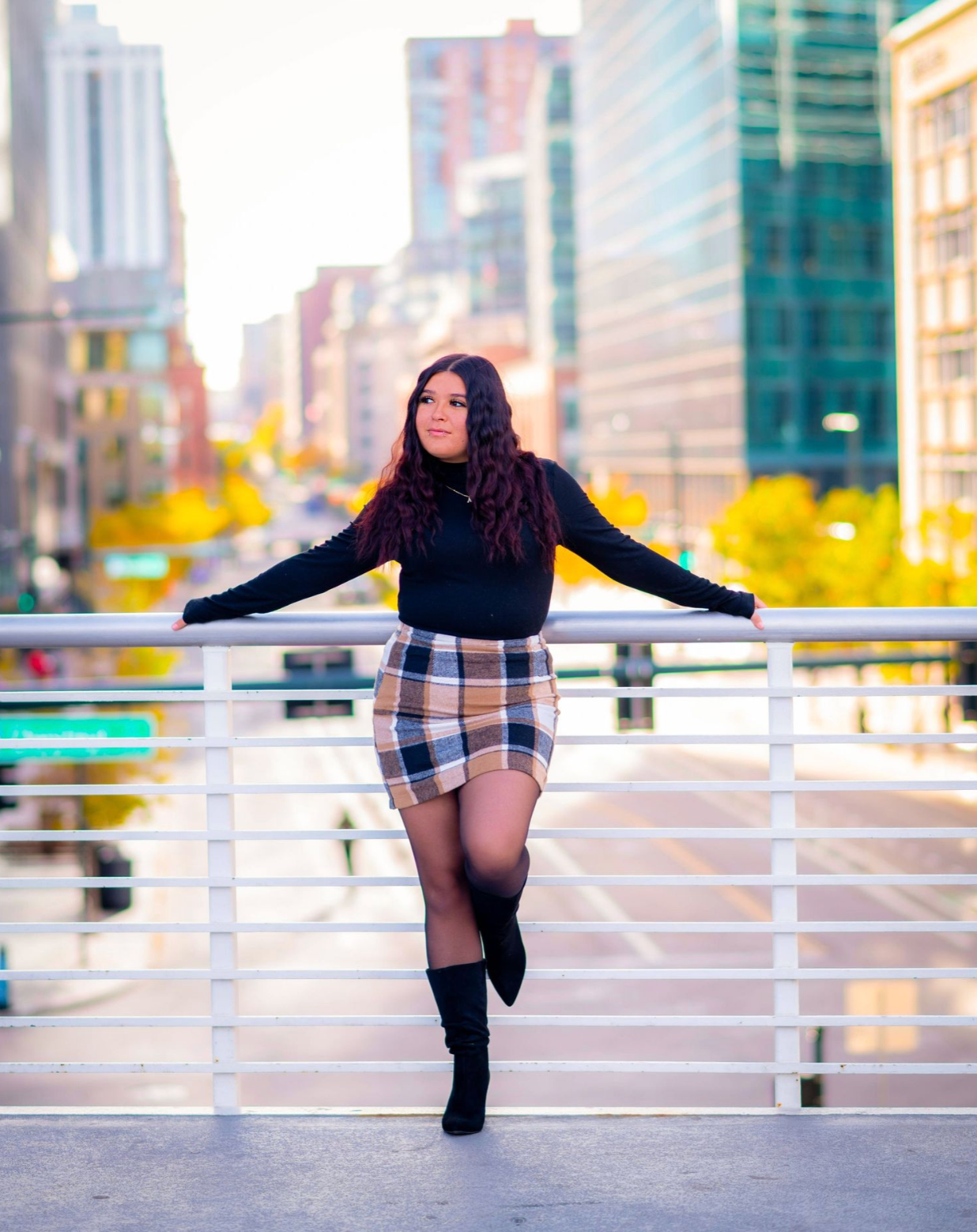 Urban dance photoshoot with ballet poses against city buildings and railings.