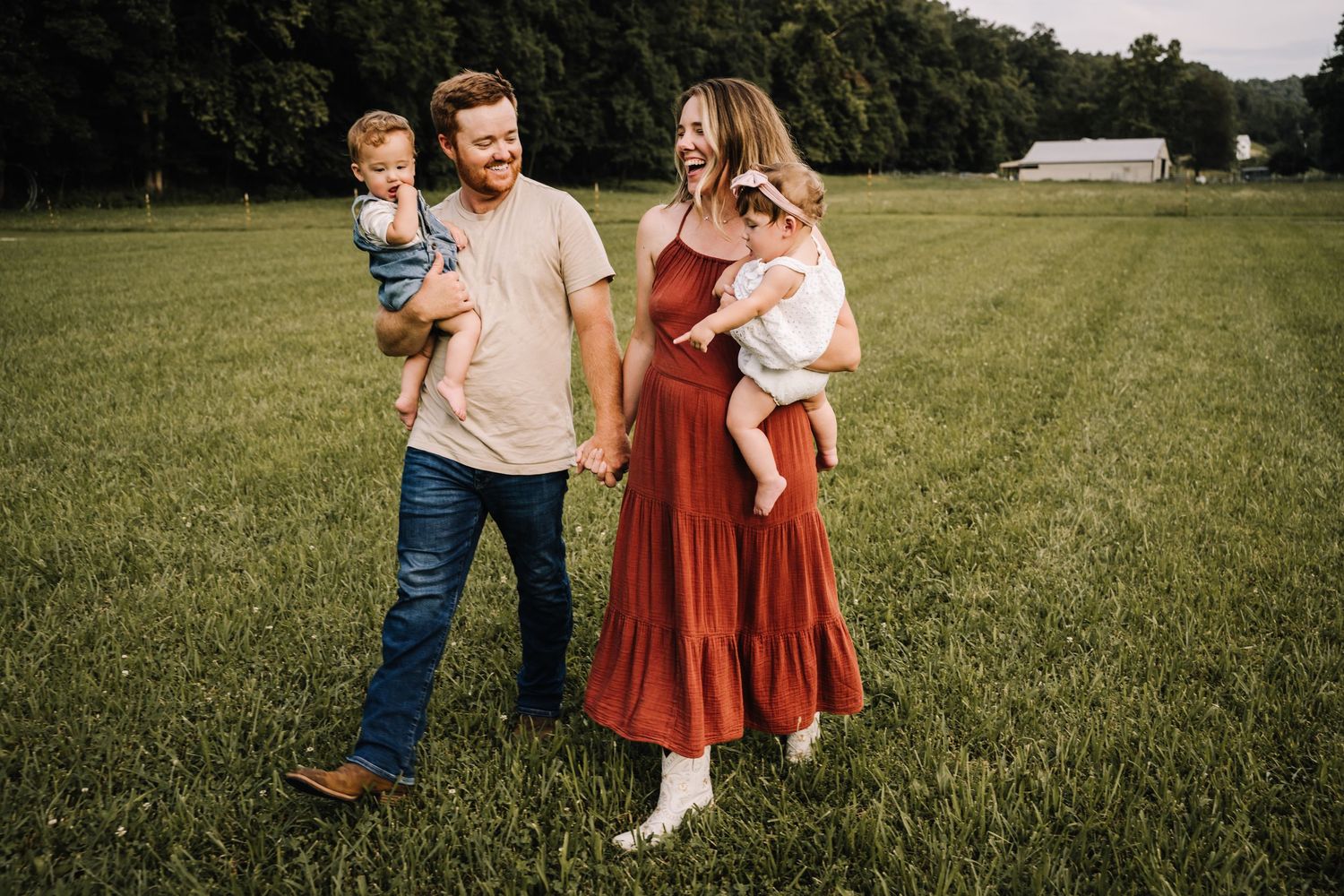 Family enjoying a playful moment together in a lush green field during golden hour. Family photographer in Middle Tennessee capturing natura