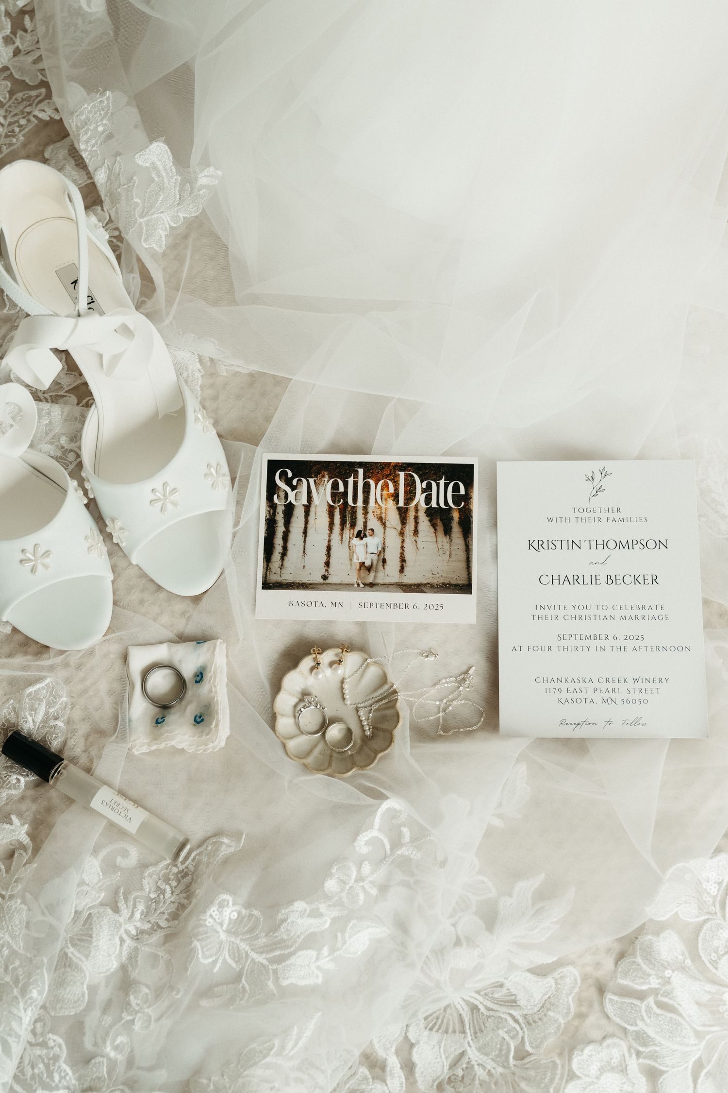 A white wedding dress hangs elegantly on a hanger against a light wall, showcasing its full-length silhouette and train.