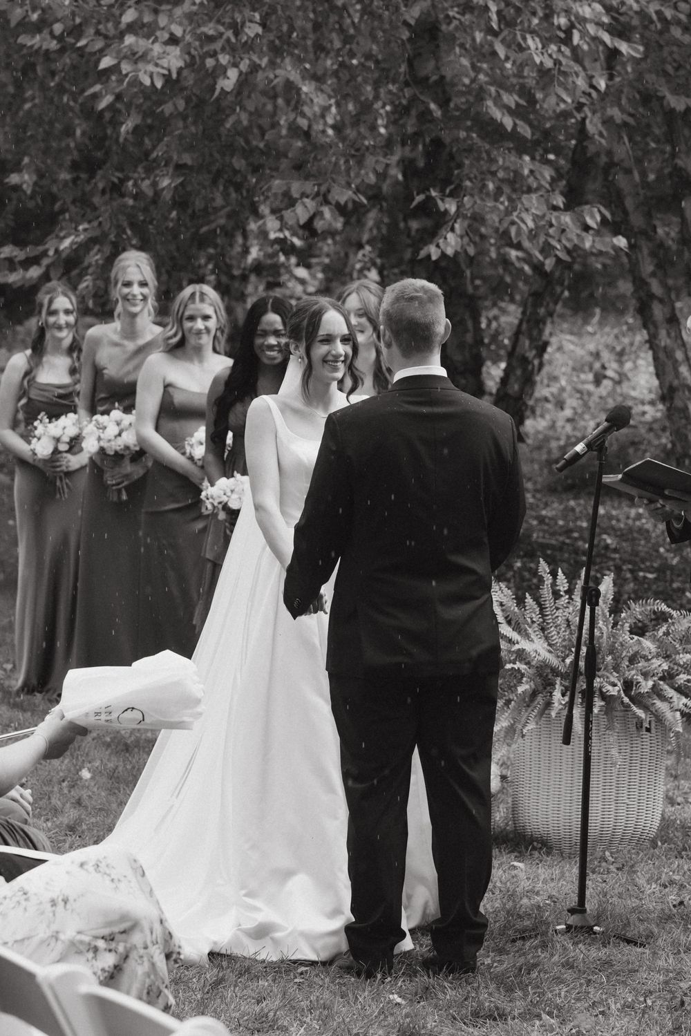 Wedding party poses outdoors in black and white photo series showing candid moments during ceremony and celebration.