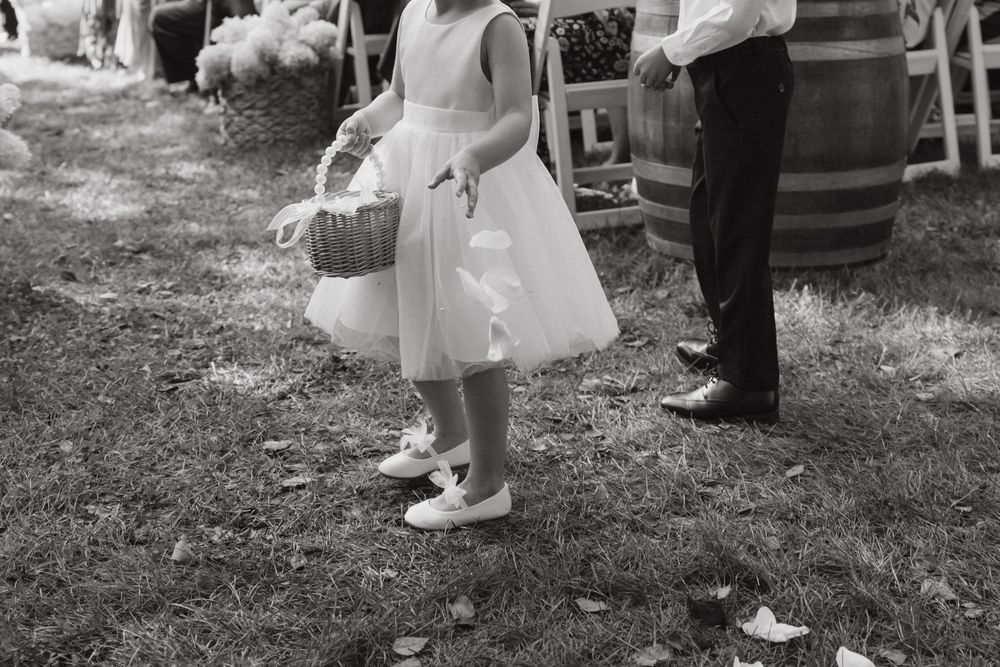 A collection of black and white wedding photos showing guests and details of an outdoor celebration.