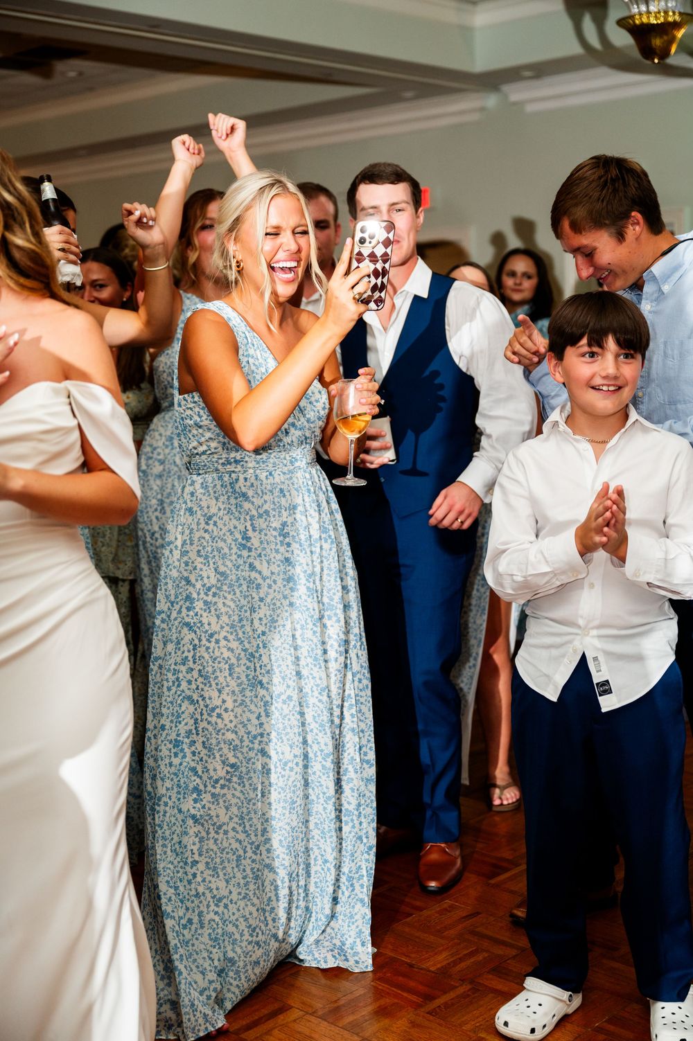 Wedding party dancing and celebrating with guests in formal attire.