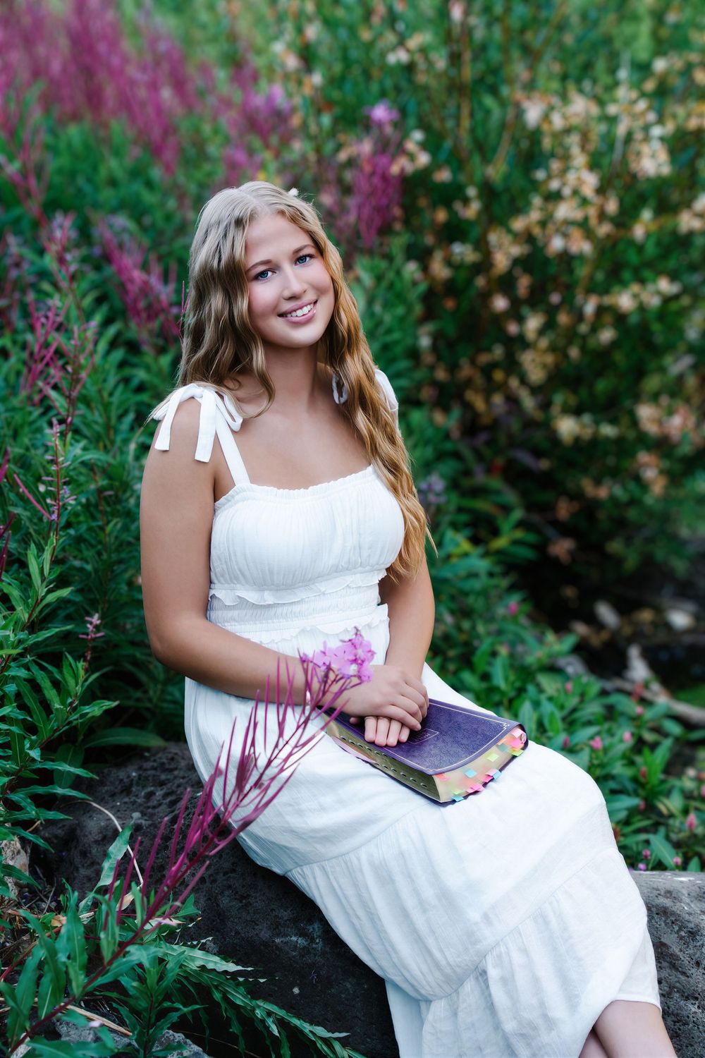 female sitting smiling holding bible in lap