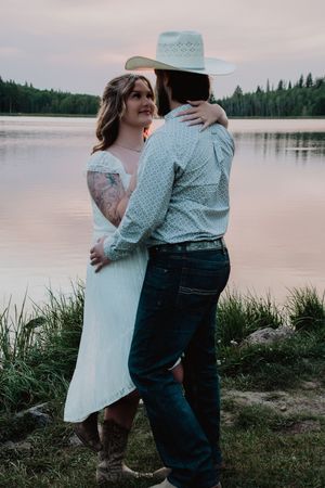 couple embracing each other having an intimate moment near a lake at sunset