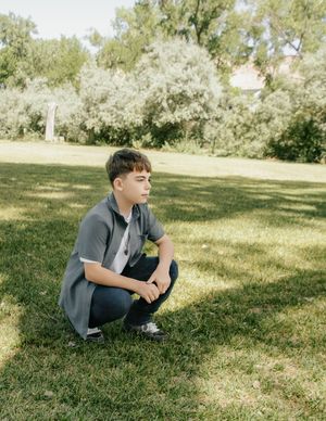 young squatting down looking off into the distance