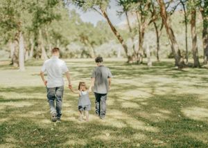 3 children holding hands walking off into distance