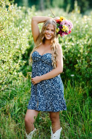 female standing posing holding flowers over head