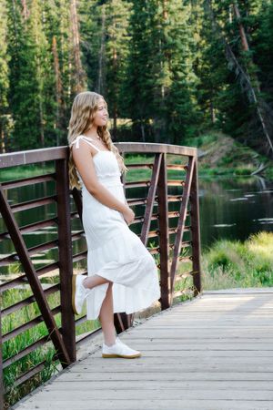 female standing on bridge looking off into distance