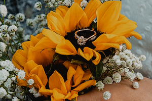 close up detail of an engagement ring laying on a sunflower