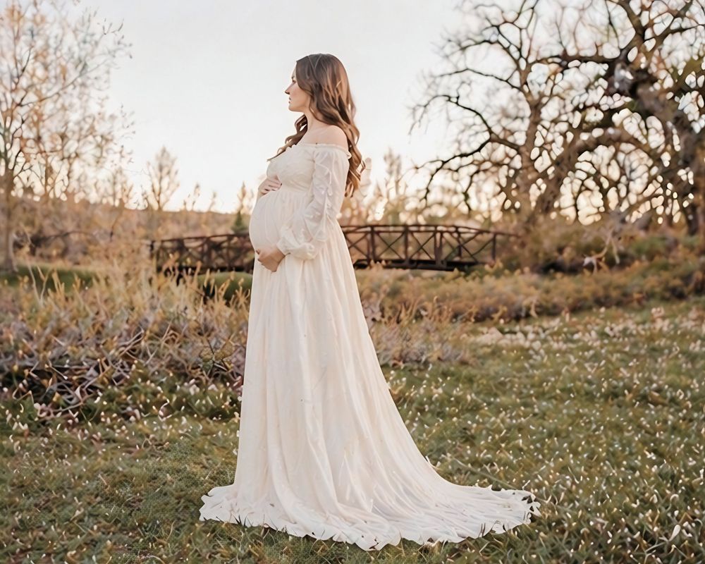Side profile maternity photoshoot with expecting mother in flowing dress outdoors