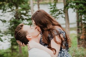 a man holding a woman up having an intimate kissing moment