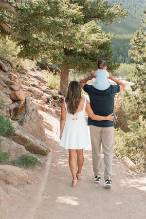 a family walking away along a path with baby on dads shoulders