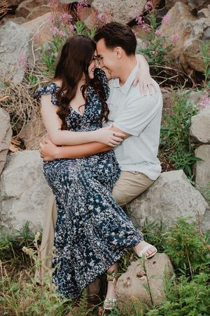 a couple sitting holding each other smiling, giggling and touching foreheads.