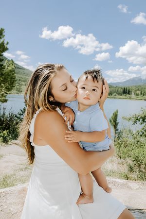 a female holding her baby kissing the babies cheek