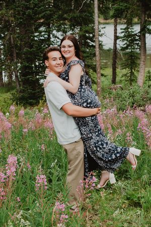 a man holding a woman up hugging each other smiling