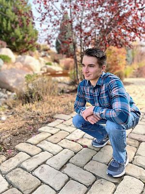 High school senior portrait of young man in casual outfit with autumn colors