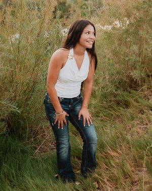 Female standing near tall grass laughing