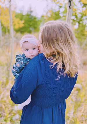 Candid mommy and me session capturing joyful moment with baby outdoors
