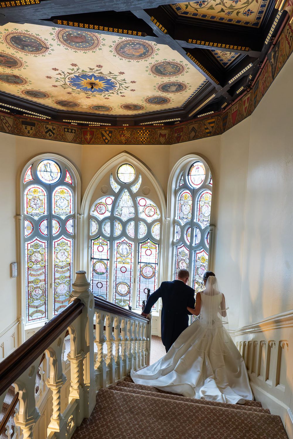 Father leads bride down stairs in grand historic house in Kent