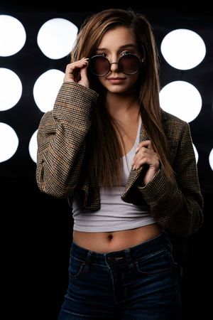 Charleston editorial style studio portrait of woman in blazer with circular light backdrop