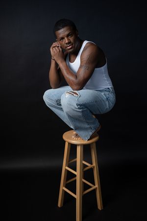 Charleston dramatic men’s studio portrait of male model in white tank top on black background