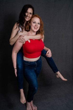 Charleston women’s studio portrait of two women smiling against dark gray background.