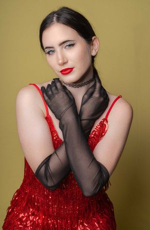 Charleston fine art glamour portrait of woman in red sequin dress on gold background.