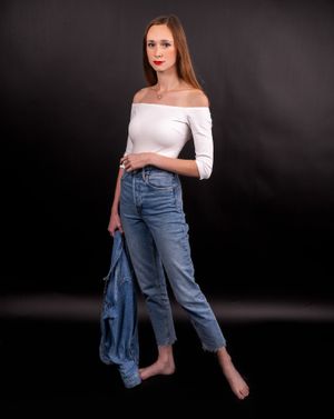 Charleston contemporary studio portrait of woman in white off-shoulder top and denim jeans