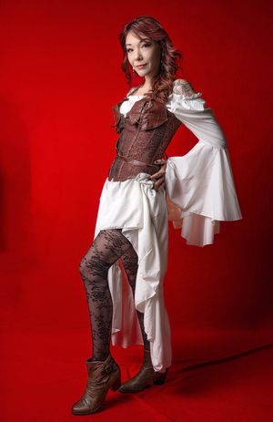 Charleston modern glamour studio portrait of woman in red and black corset on red background.