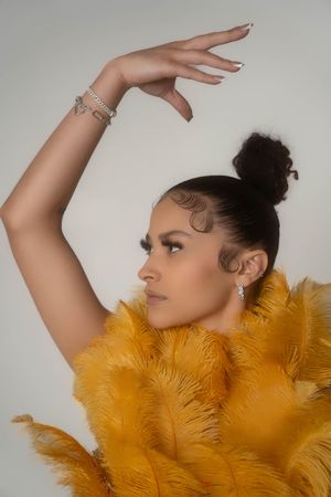 Charleston fashion inspired studio portrait of woman wearing yellow feather statement piece