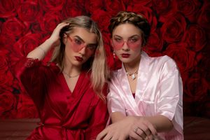 Summerville SC women’s Galentine photo session with red and pink satin robes on rose backdrop