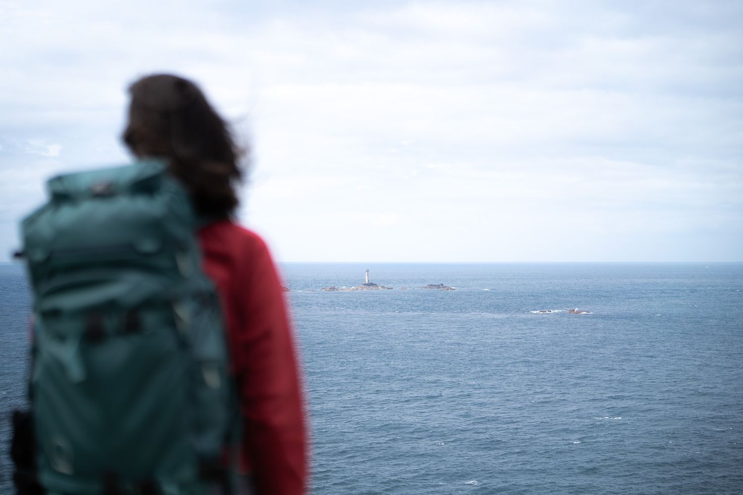 randonneuse devant le phare de longships à lands end dans les cornouailles en angleterre