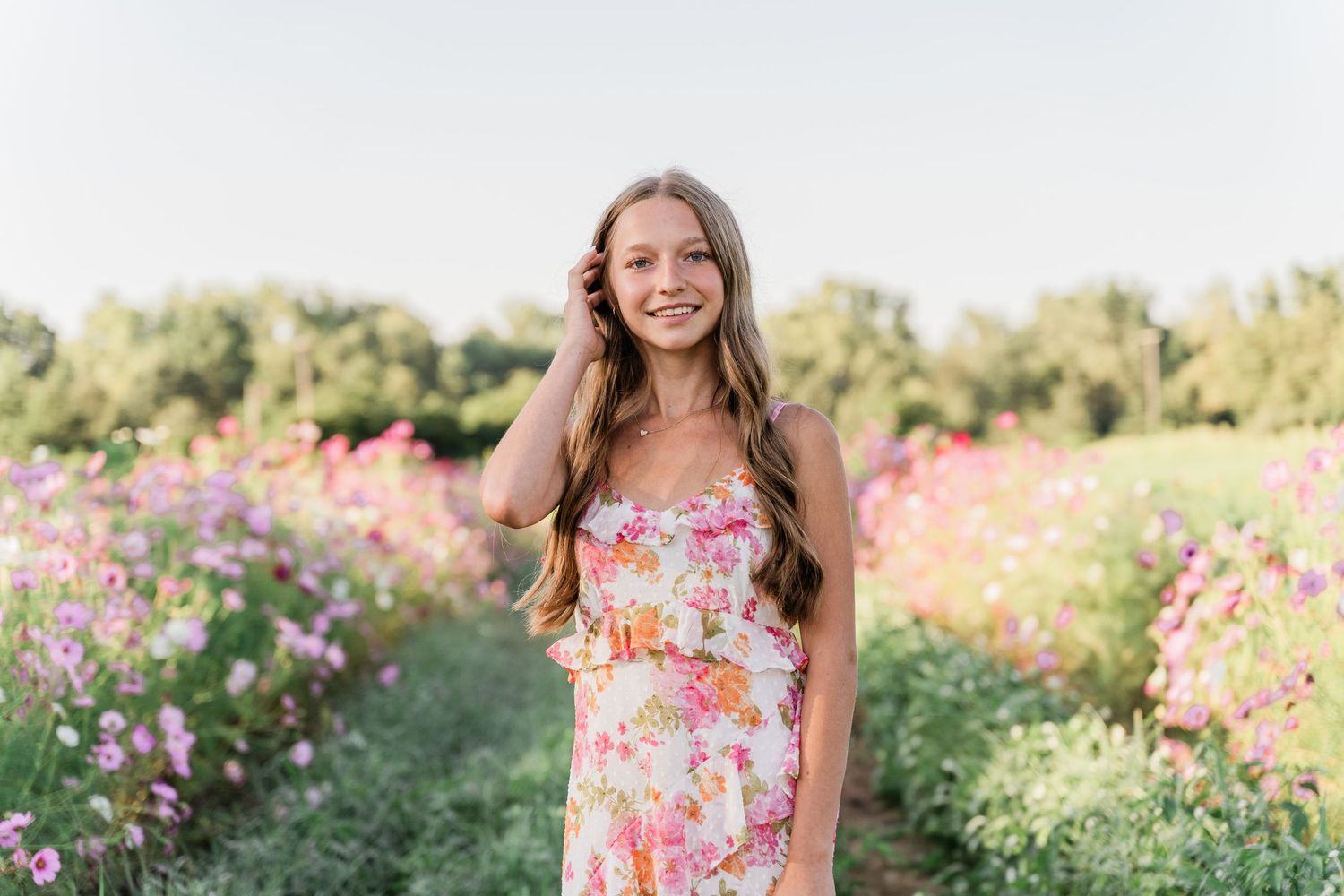 Perrysburg High School senior poses in a floral dress among vibrant pink cosmos flowers at GardenView Flowers