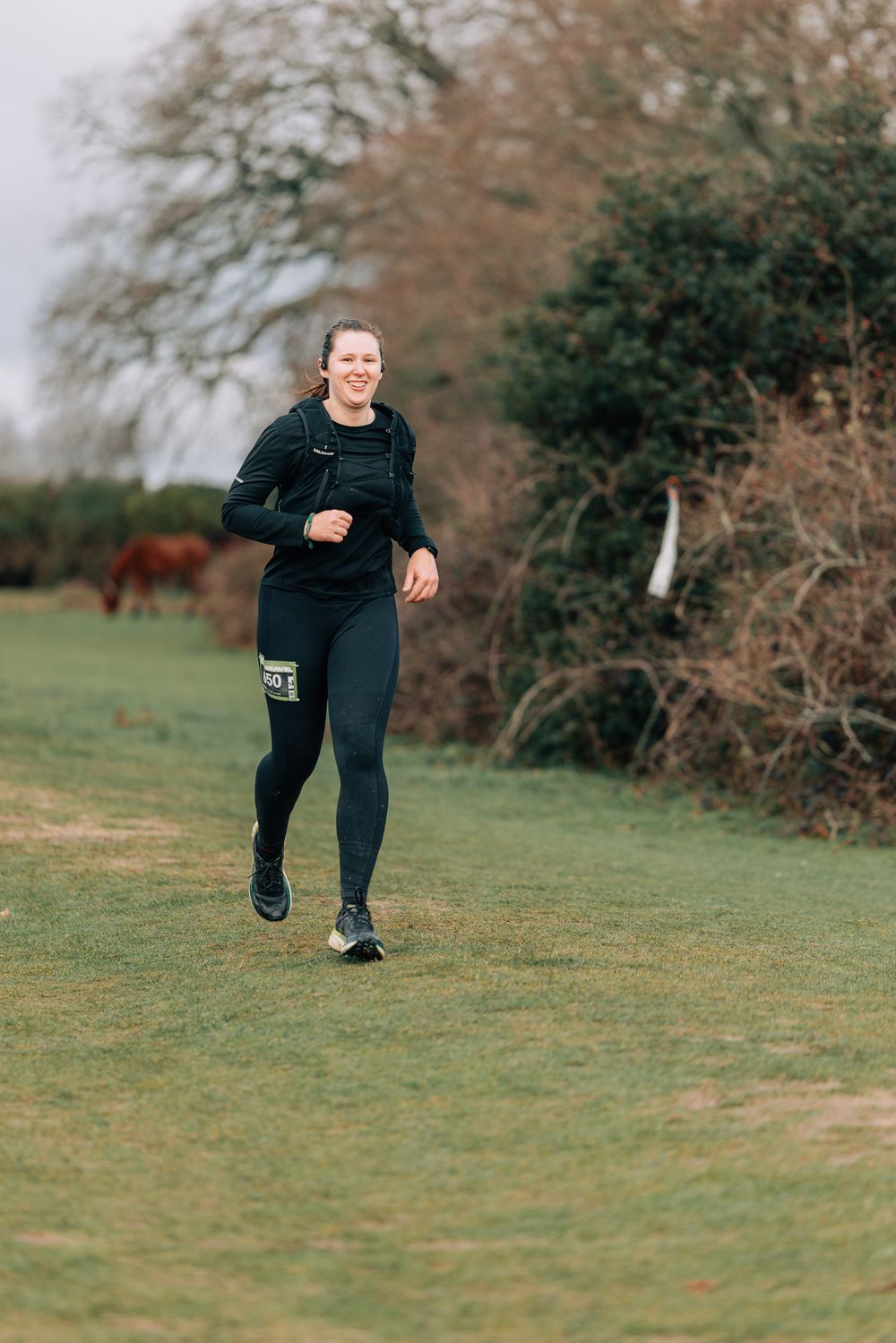 A sequence showing someone running and jumping across a grassy field in dark athletic wear.