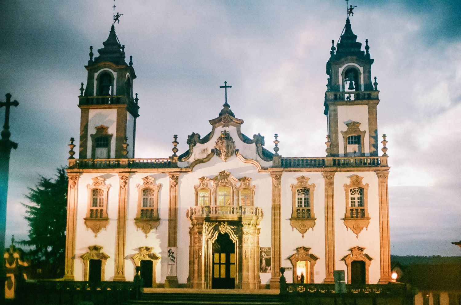 Panoramic view of the baroque Bom Jesus do Monte church in Braga, Portugal with dramatic cloudy sky at dusk.
