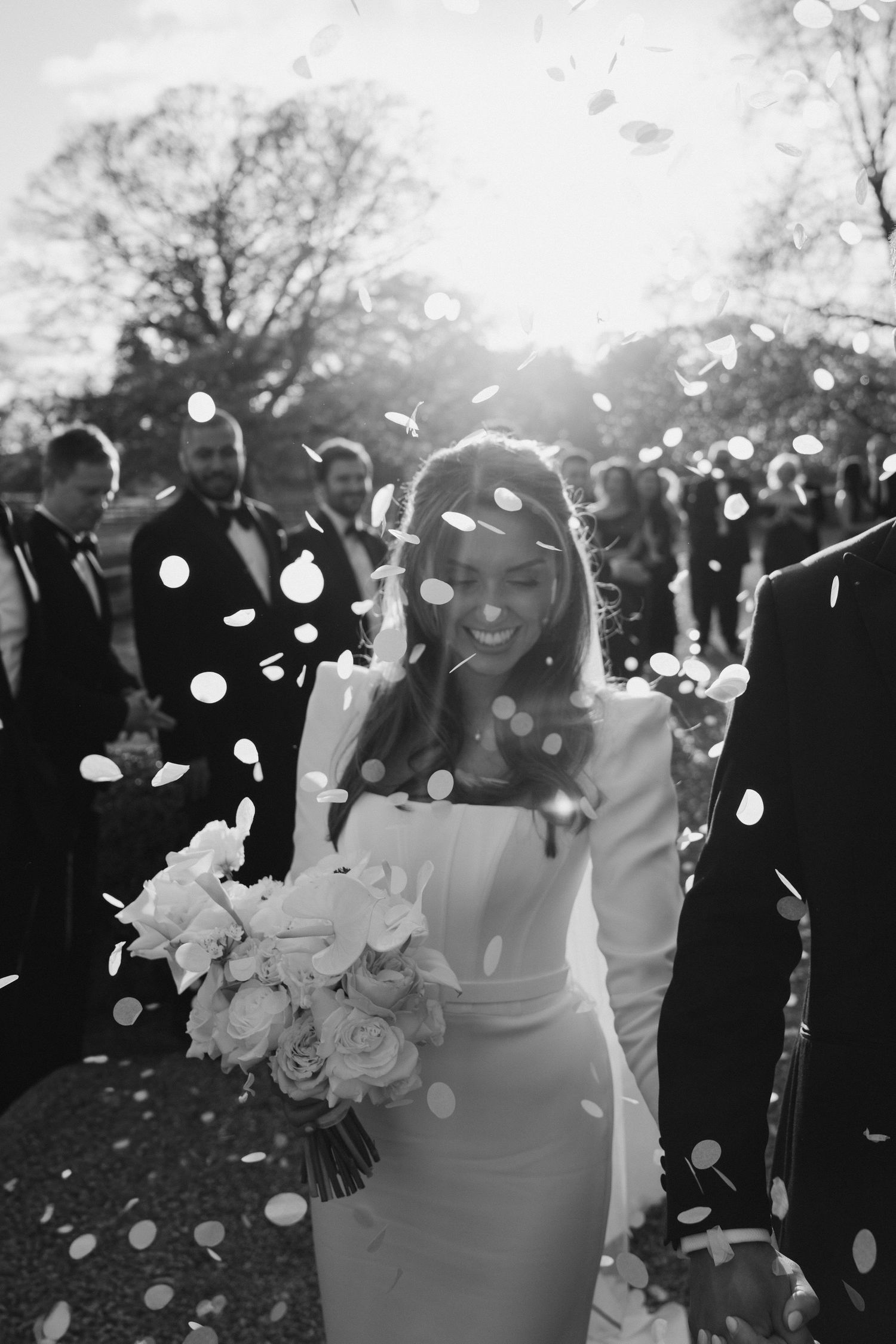 wedding guests throwing confetti over the bride and groom at Iscoyd park