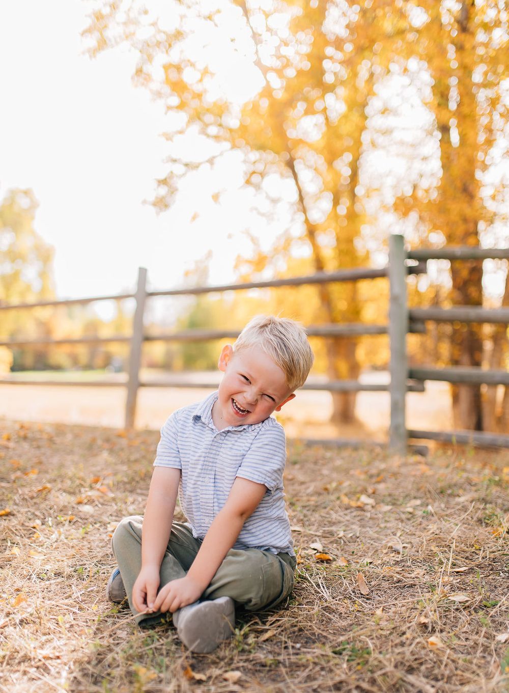 Candid lifestyle photos of playful moments on a grassy hillside during golden autumn afternoon light.