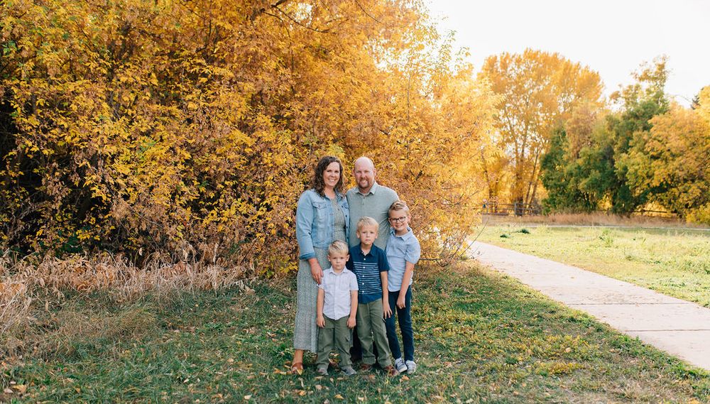 A series of outdoor family portraits captured during golden hour in a scenic autumn setting with warm fall foliage.