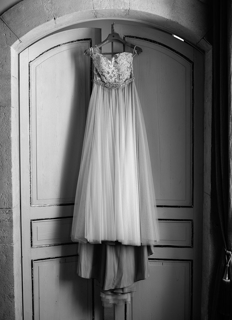 Wedding dress hanging on vintage door at Château de Massillan in Provence