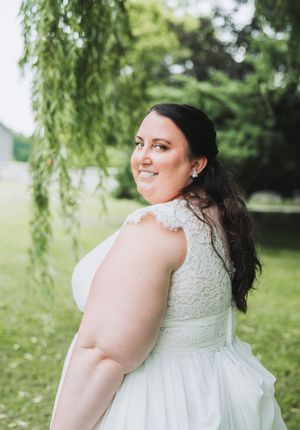 A white lace wedding dress with delicate beading detail photographed outdoors.