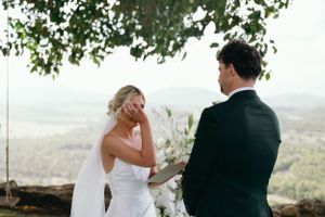 Emotional wedding ceremony moment at scenic outdoor hilltop location.