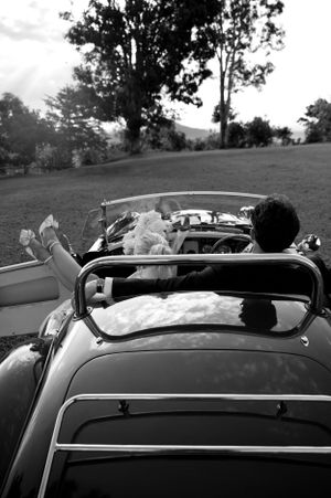 Black and white photo of a classic convertible car on a hillside.