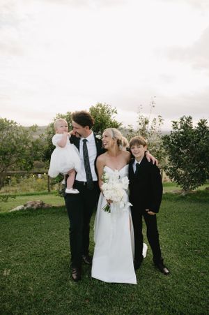 Wedding party gathering on lush green lawn during outdoor celebration.