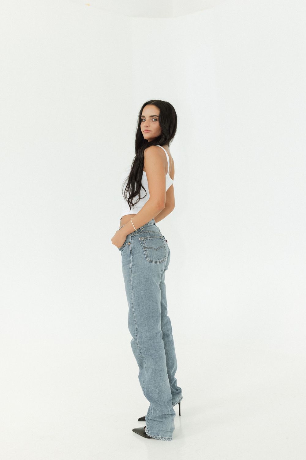 Model wearing light wash denim overalls poses against white backdrop showing different angles and views.