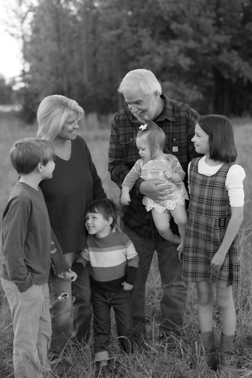 A black and white photo series shows a family interacting outdoors in casual clothing against a natural backdrop.