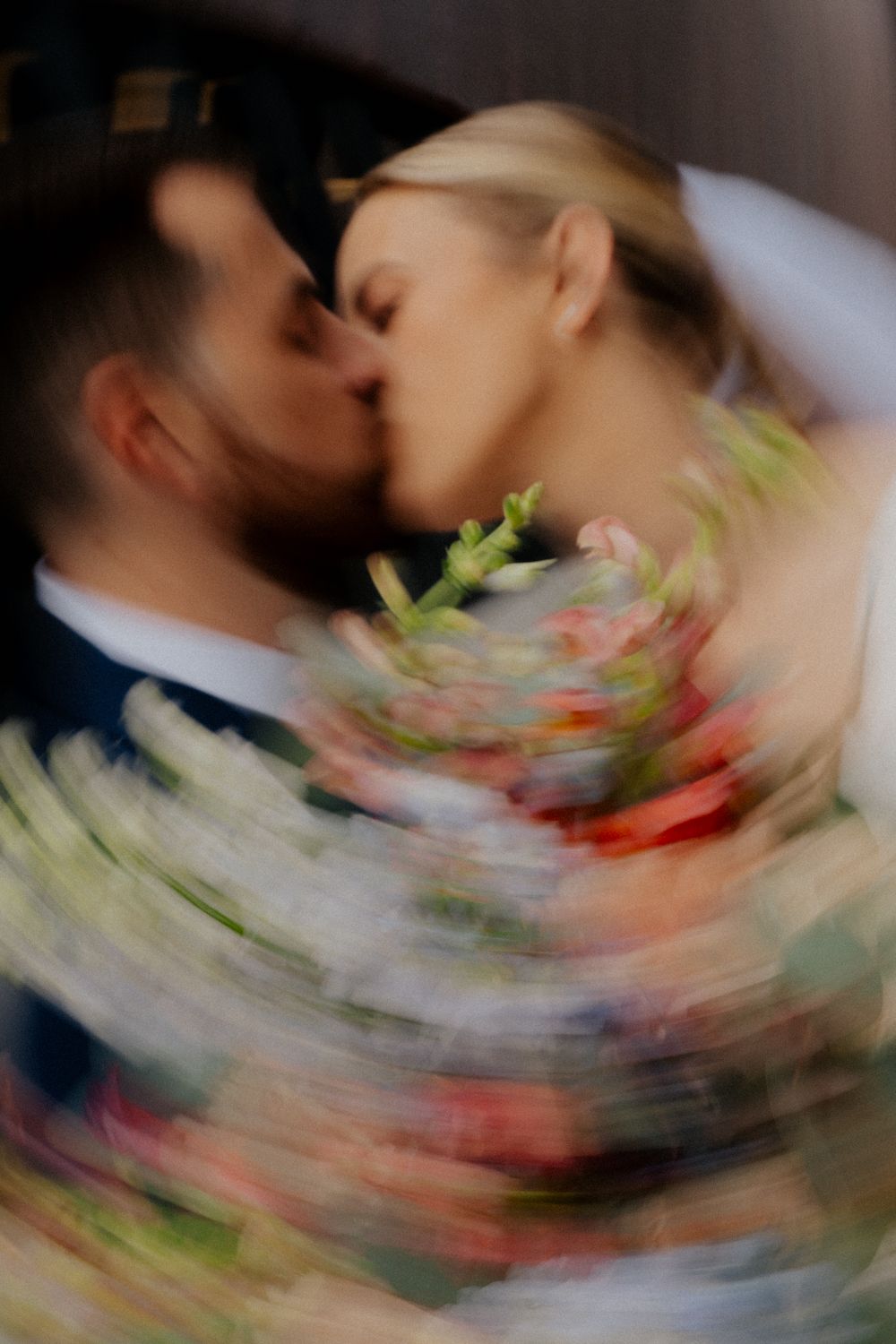 Abstract motion blur photograph showing swirling colors of pink, green and white in a spiral pattern.