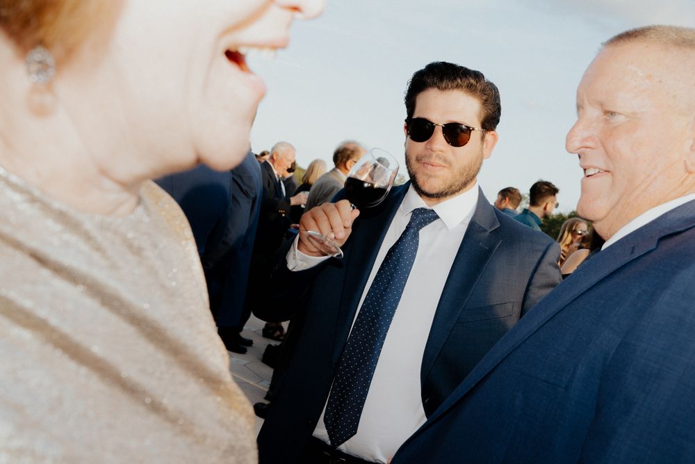 A series of candid moments at a formal event showing people in suits interacting and conversing.