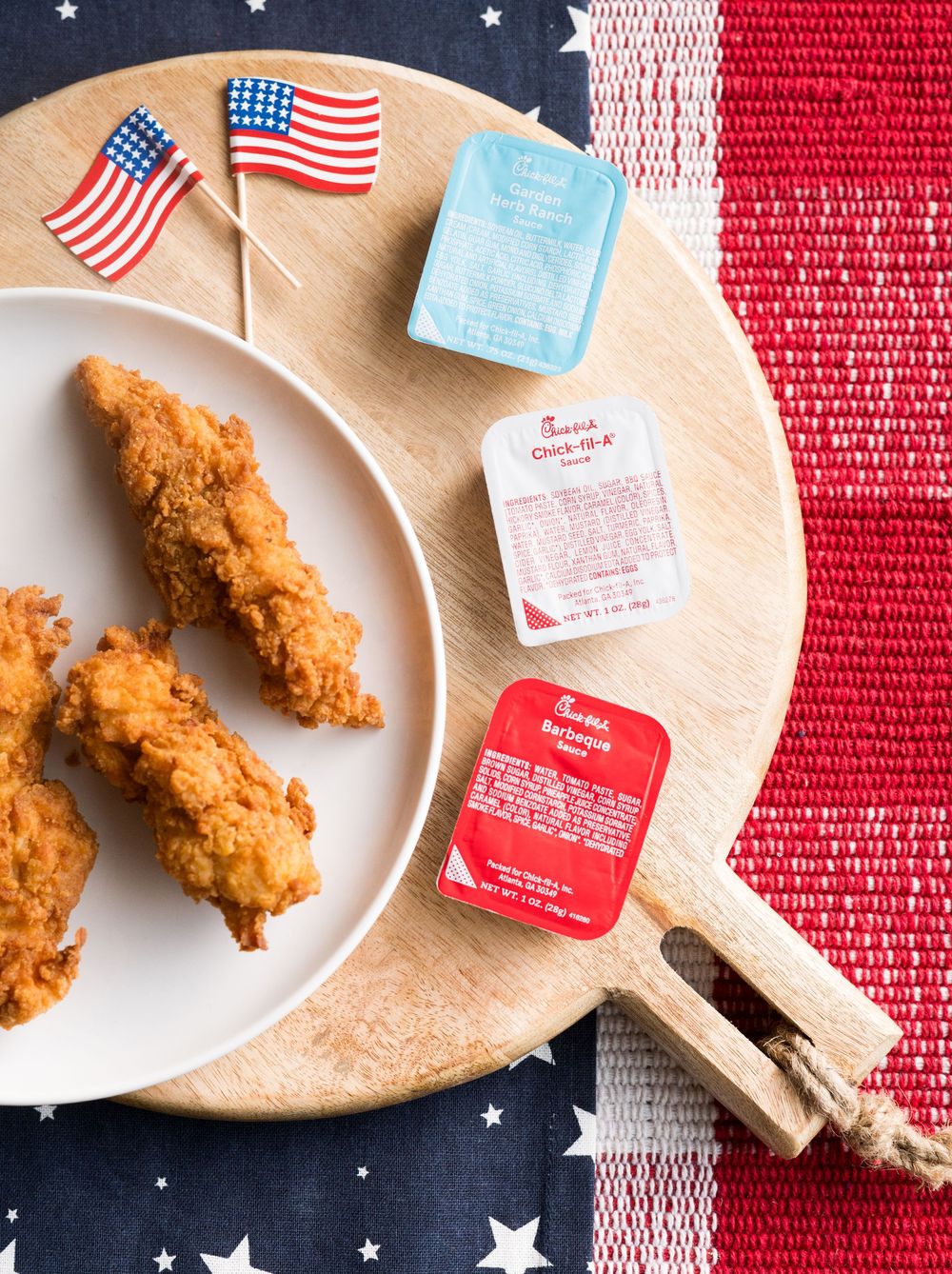Crispy chicken tenders on white plates with American flag decorations.